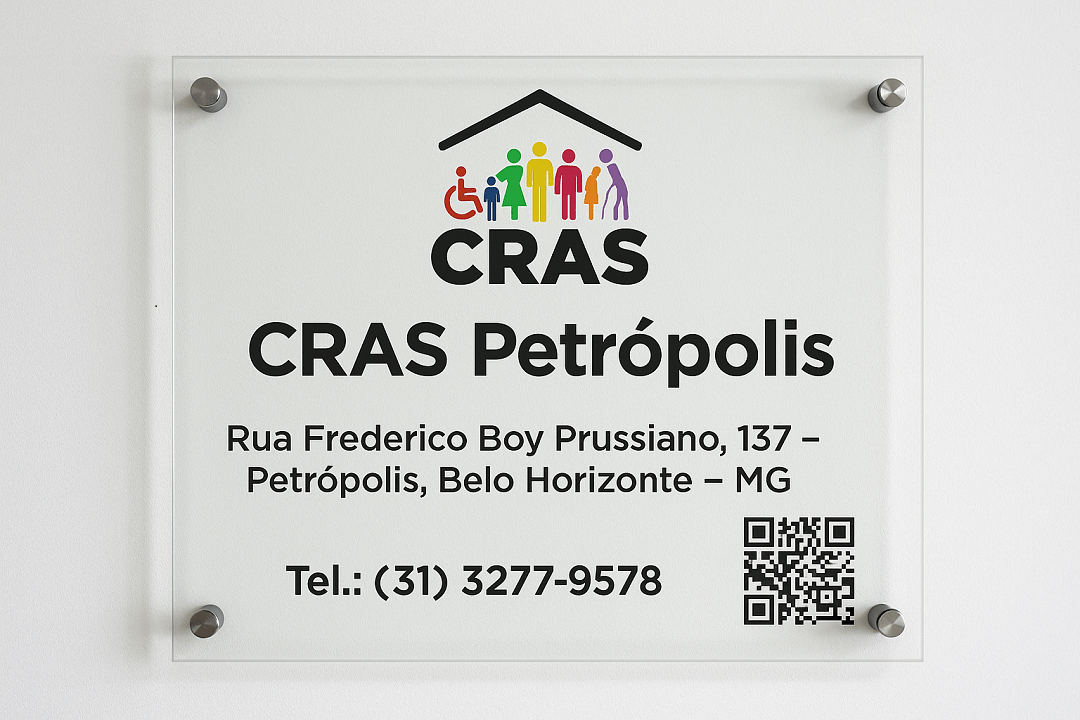 Placa de vidro montada na parede com o logotipo colorido do CRAS e os dizeres CRAS Petrópolis, Rua Frederico Boy Prussiano, 137 – Petrópolis, Belo Horizonte – MG, telefone (31) 3277-9578 e QR Code para acesso à página da unidade.